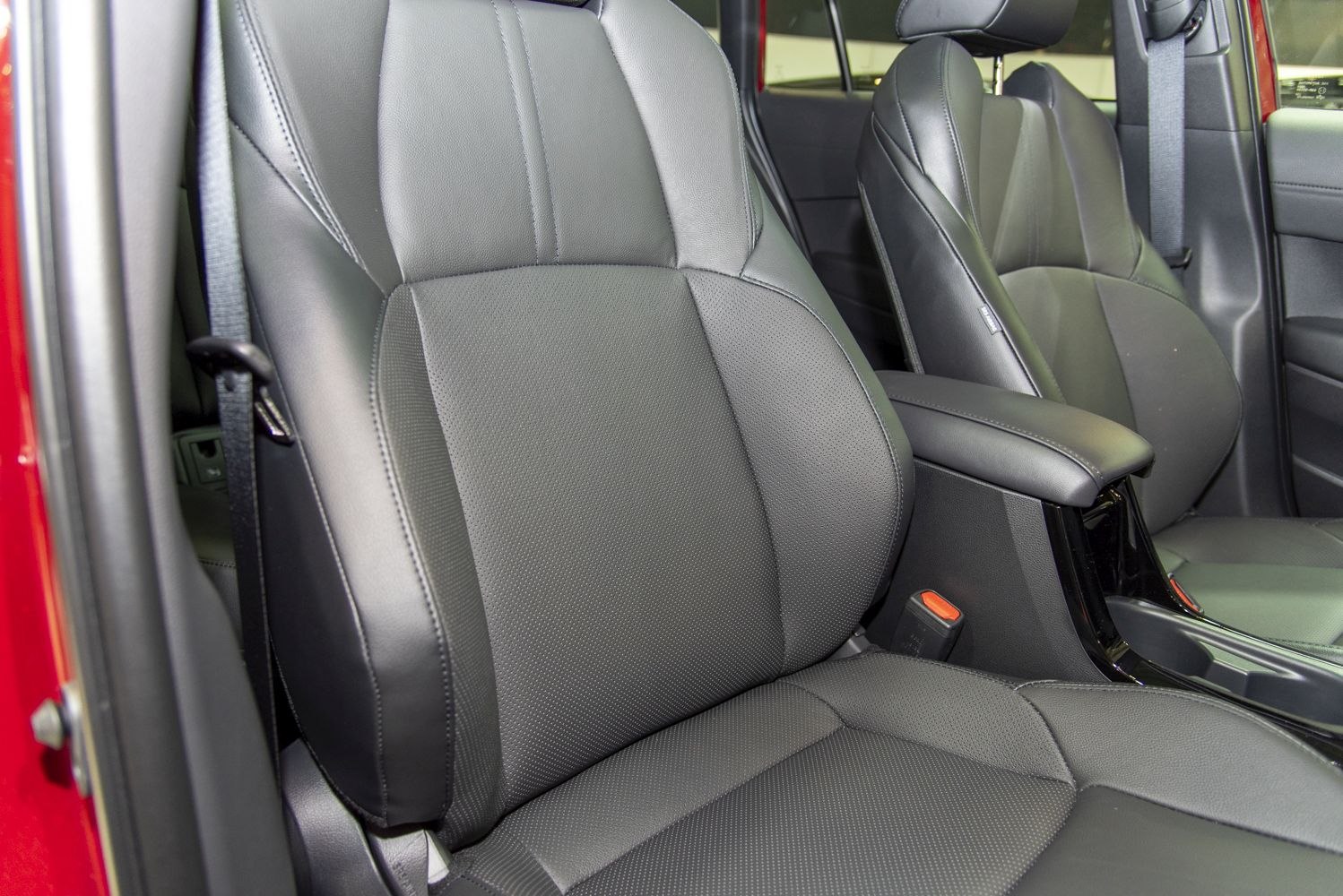 Black leather front seats with detailed stitching and armrest