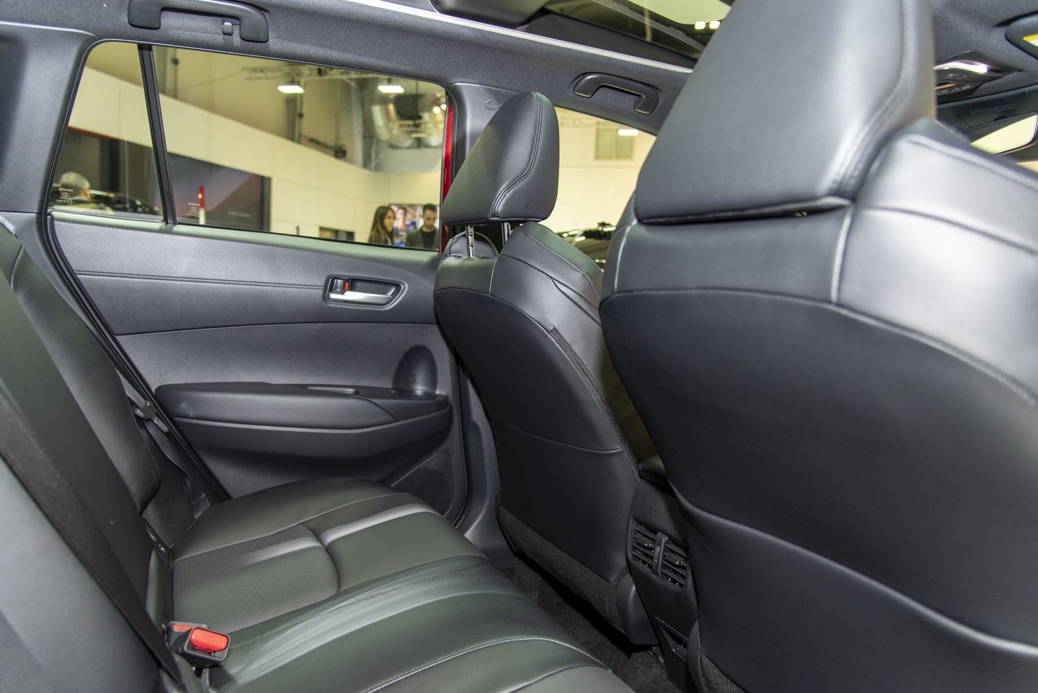 Rear interior seating with black leather upholstery and spacious legroom.