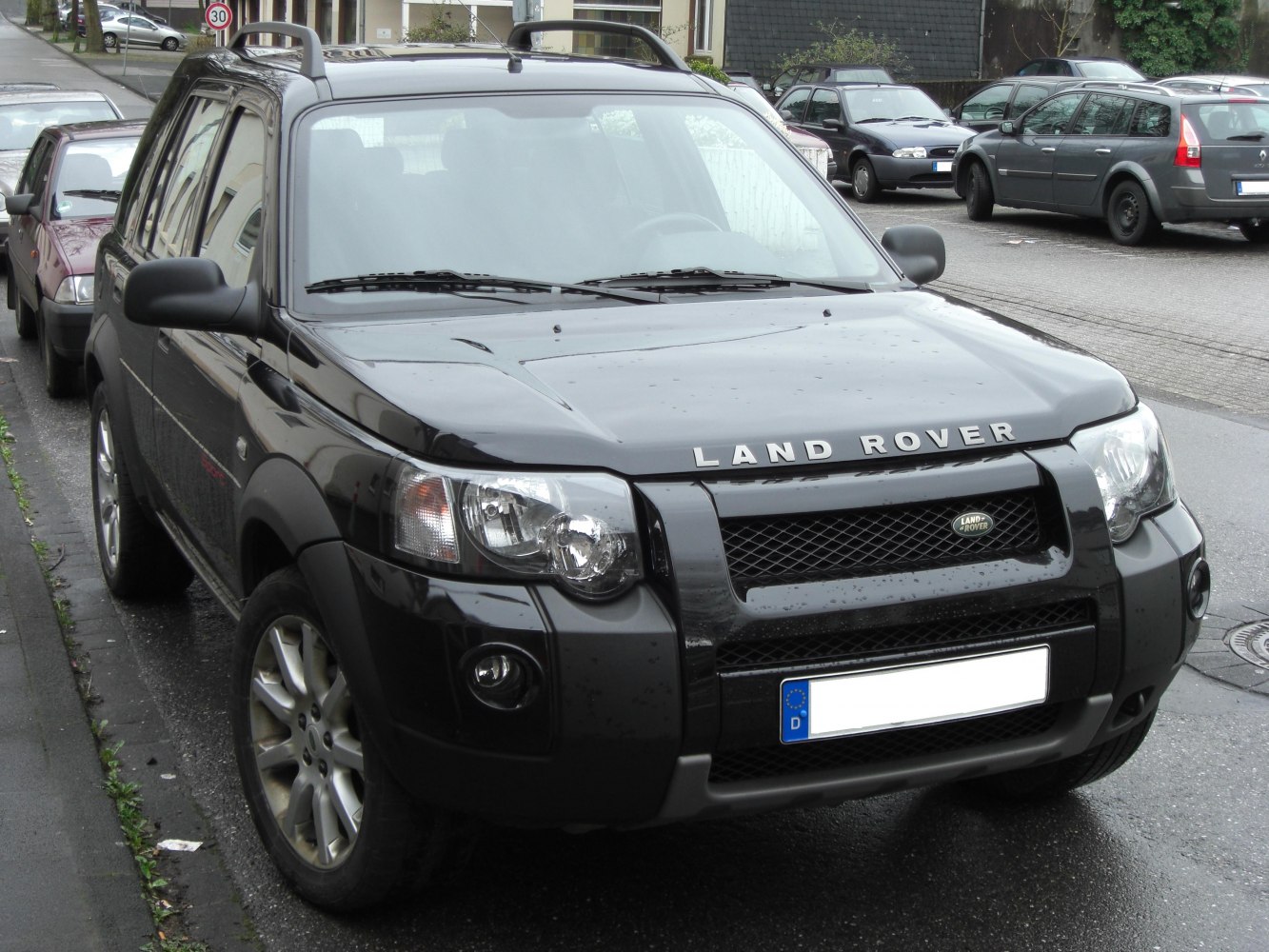 Front profile of black SUV with grille, roof rails, and round fog lights