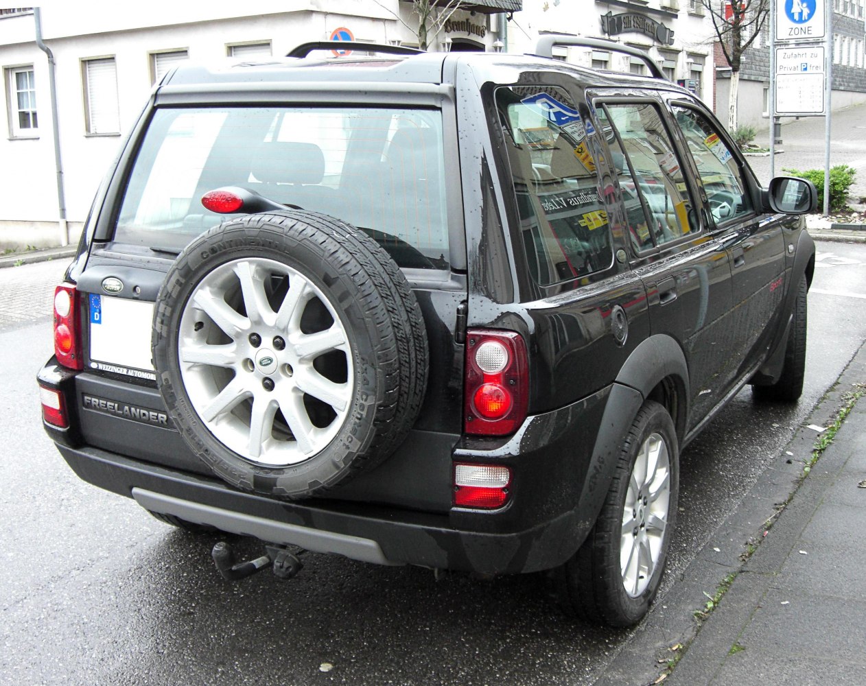 Rear view with spare wheel mounted on tailgate and notable taillight design