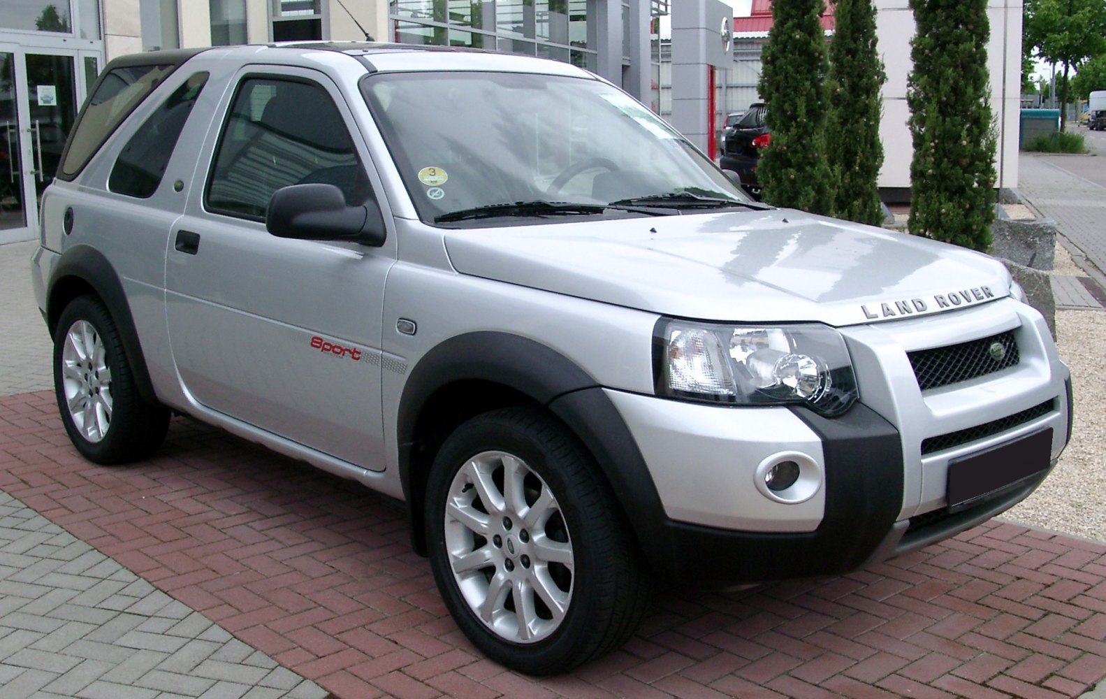 Front-side view of silver SUV with alloy wheels and prominent headlights.