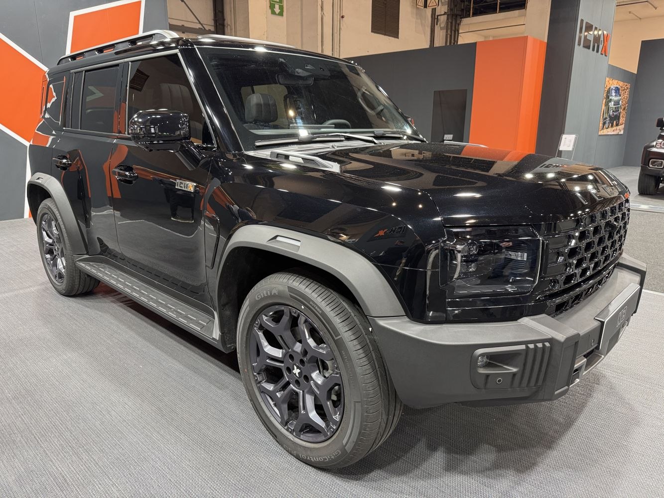 Rugged black SUV with boxy design, black alloy wheels, and integrated roof rails