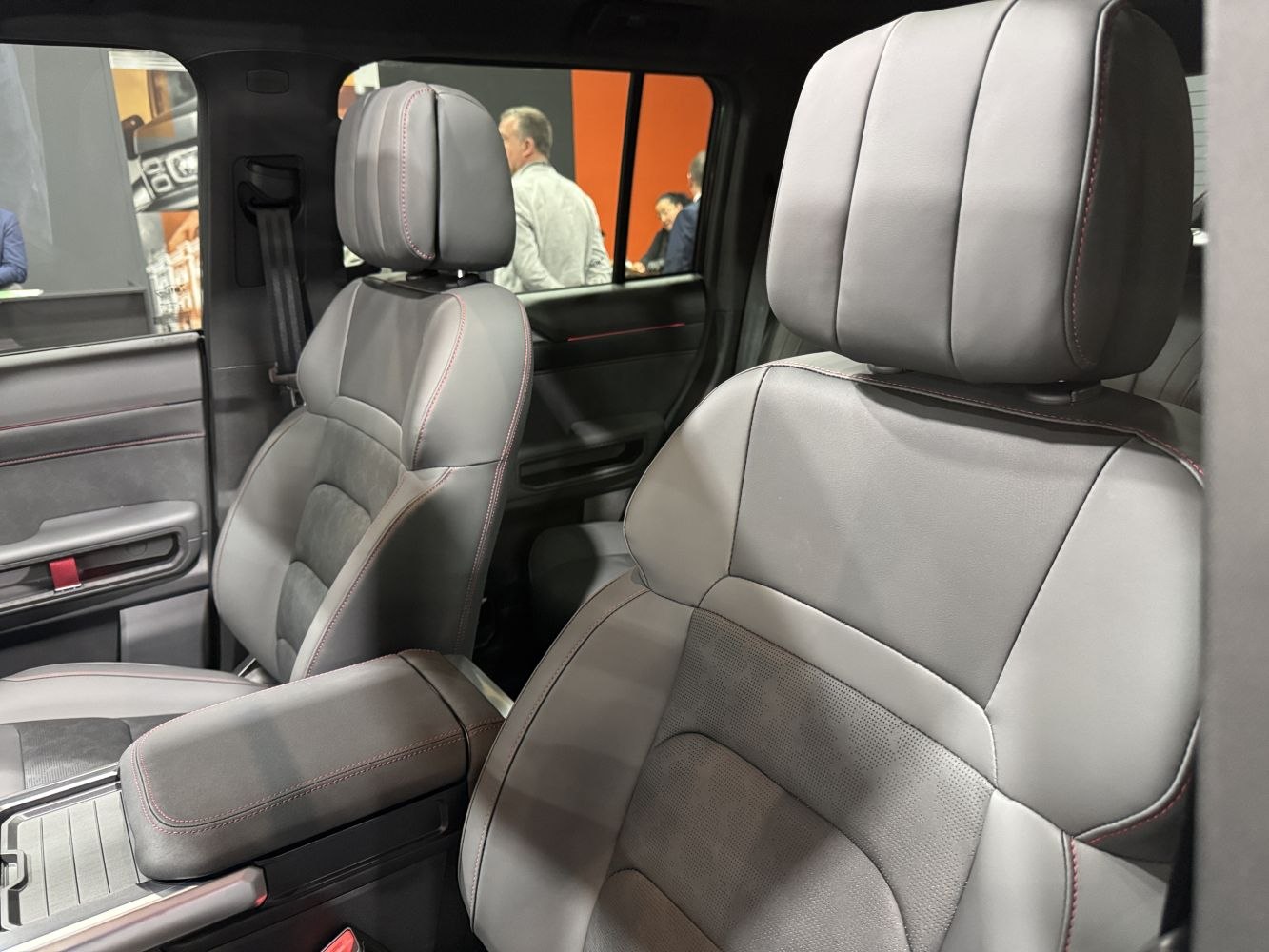 Premium leather front seats with red stitching and armrest