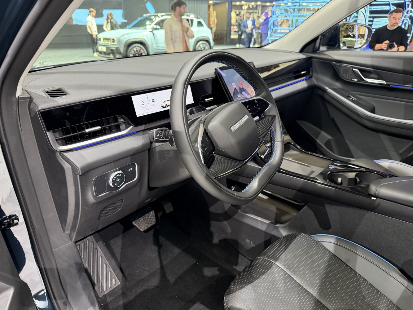 Dual digital displays and square-shaped steering wheel with ambient lighting.