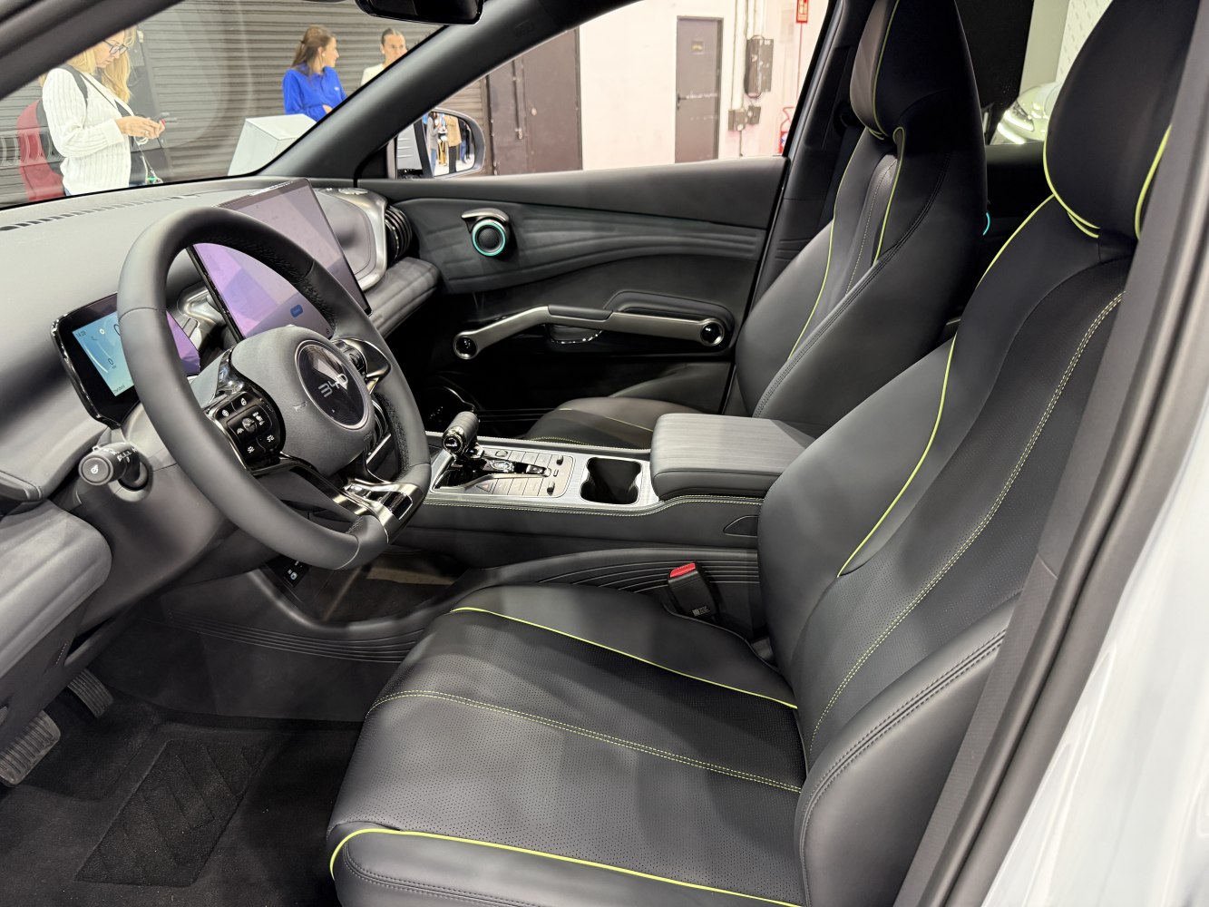 Leather seats with neon stitching and dual digital displays in a modern electric SUV