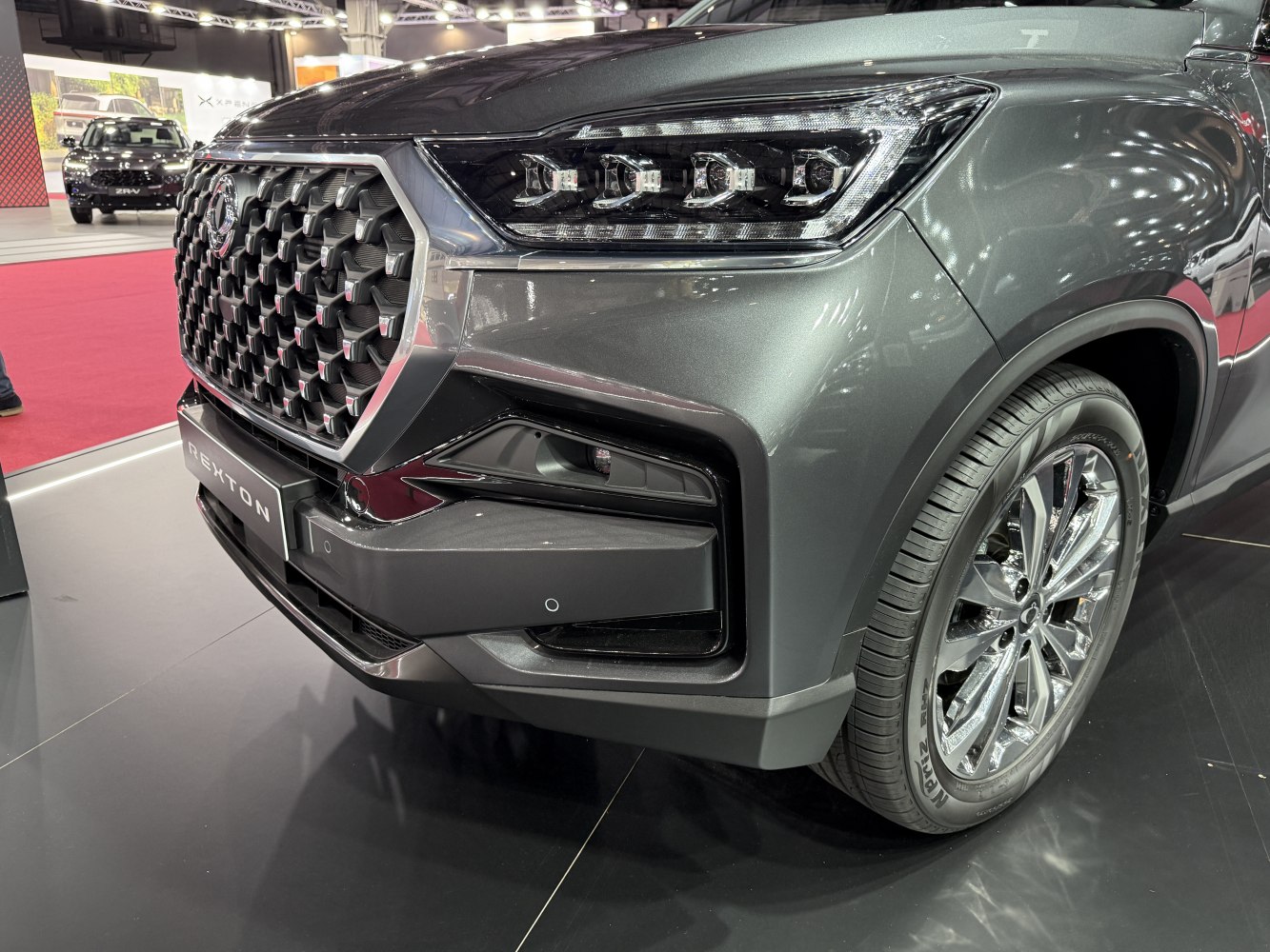 Close-up of front grille, LED headlights, and chrome wheel of a modern SUV