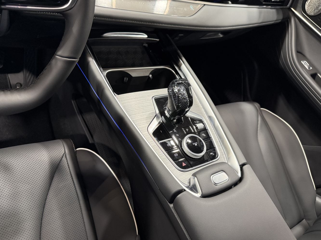 Modern gear selector and center console with controls and leather upholstery
