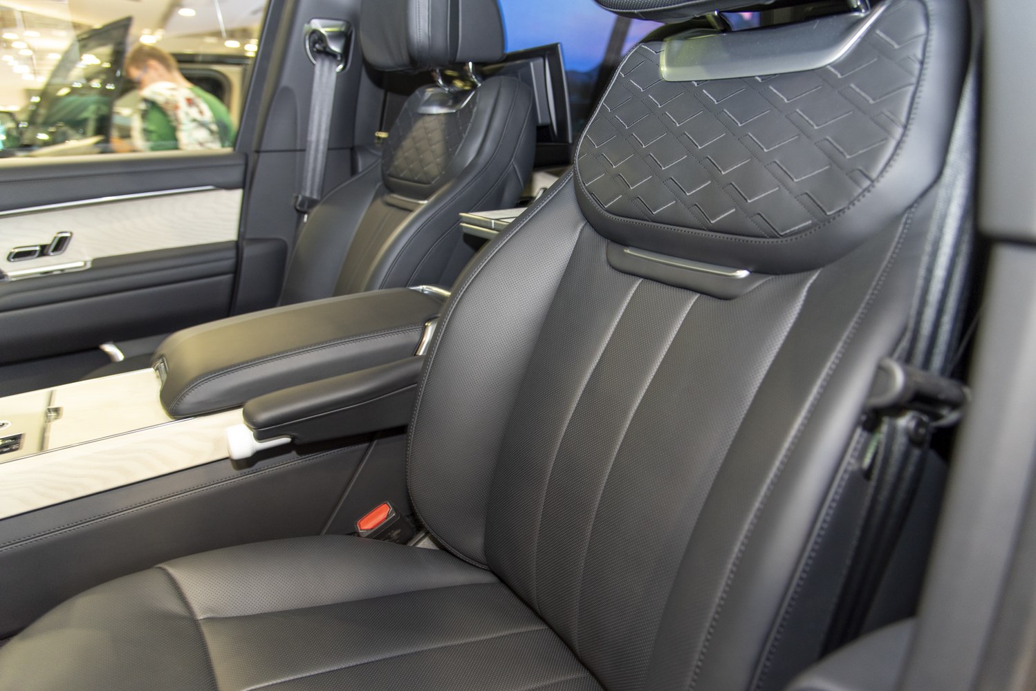 Black perforated leather front seats with detailed stitching and armrest
