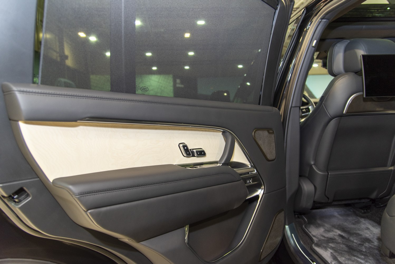 Luxury rear door panel with leather, wood trim, and seat memory controls
