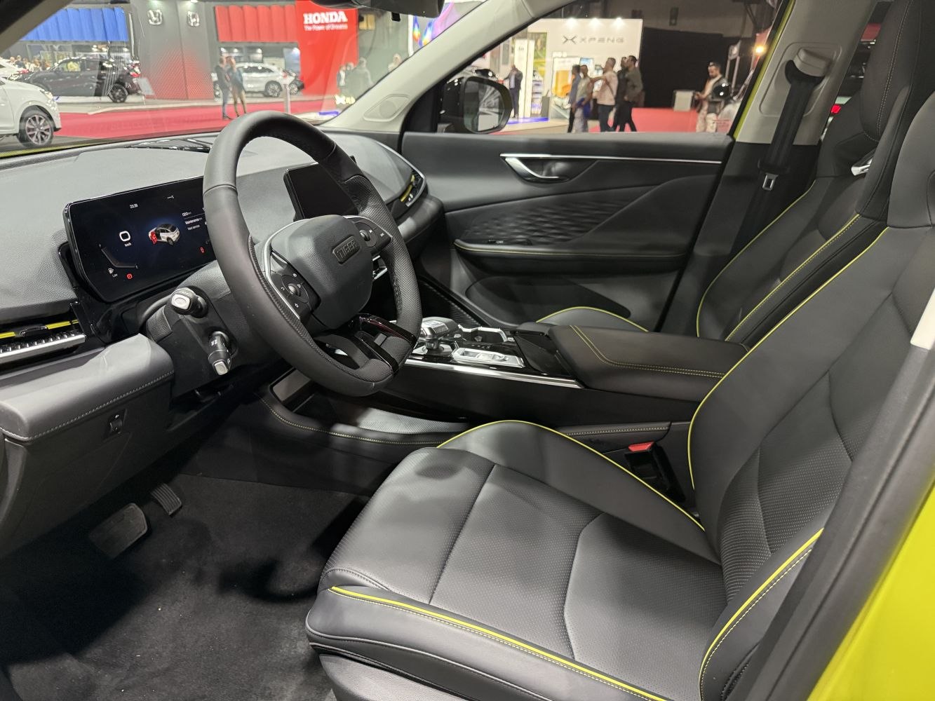 Modern digital dashboard with black leather seats featuring yellow stitching