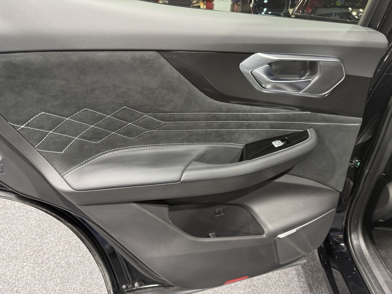 Interior door panel with diamond stitching and modern handle