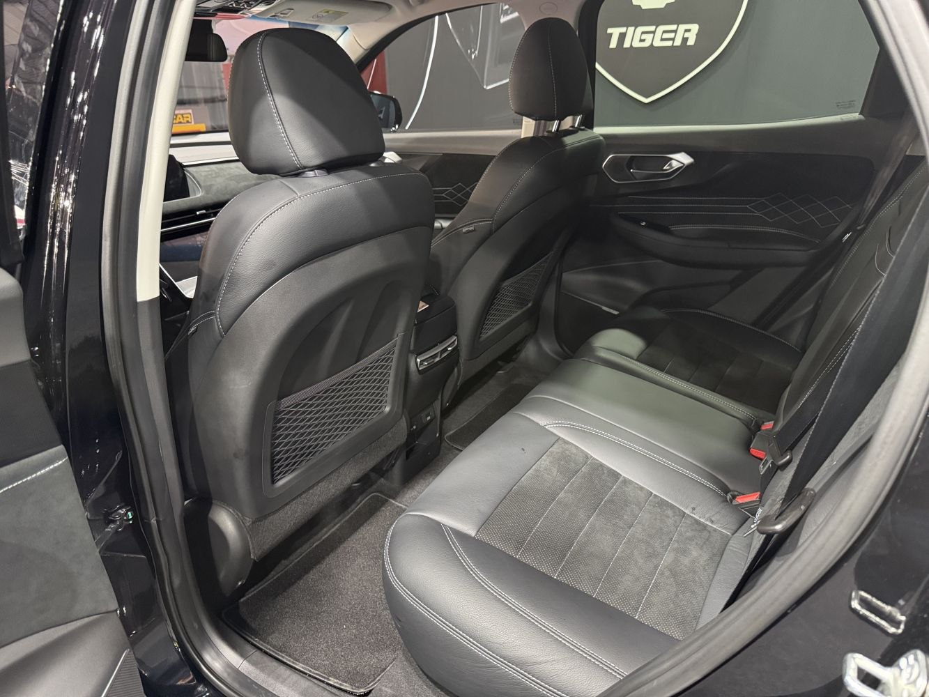Rear seats with black leather and modern stitching in spacious interior