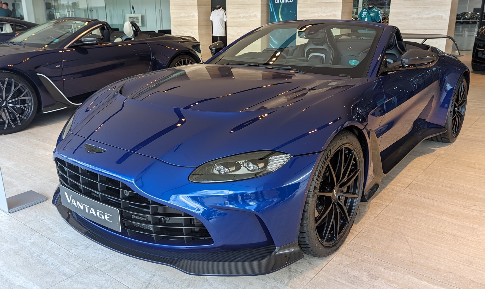 Blue convertible sports car with carbon fiber splitter and black alloy wheels