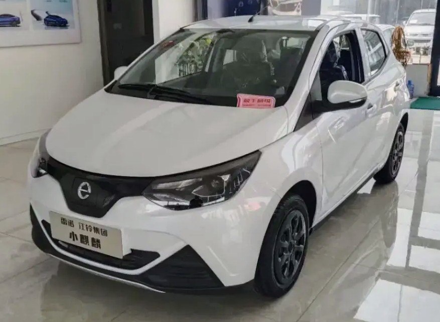 Compact electric vehicle with sleek headlights and black alloy wheels