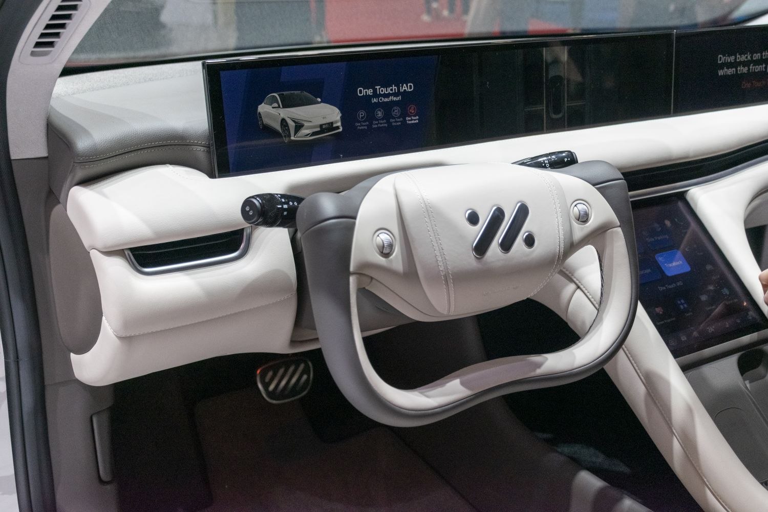 Futuristic steering wheel and expansive digital dashboard with touchscreen controls.