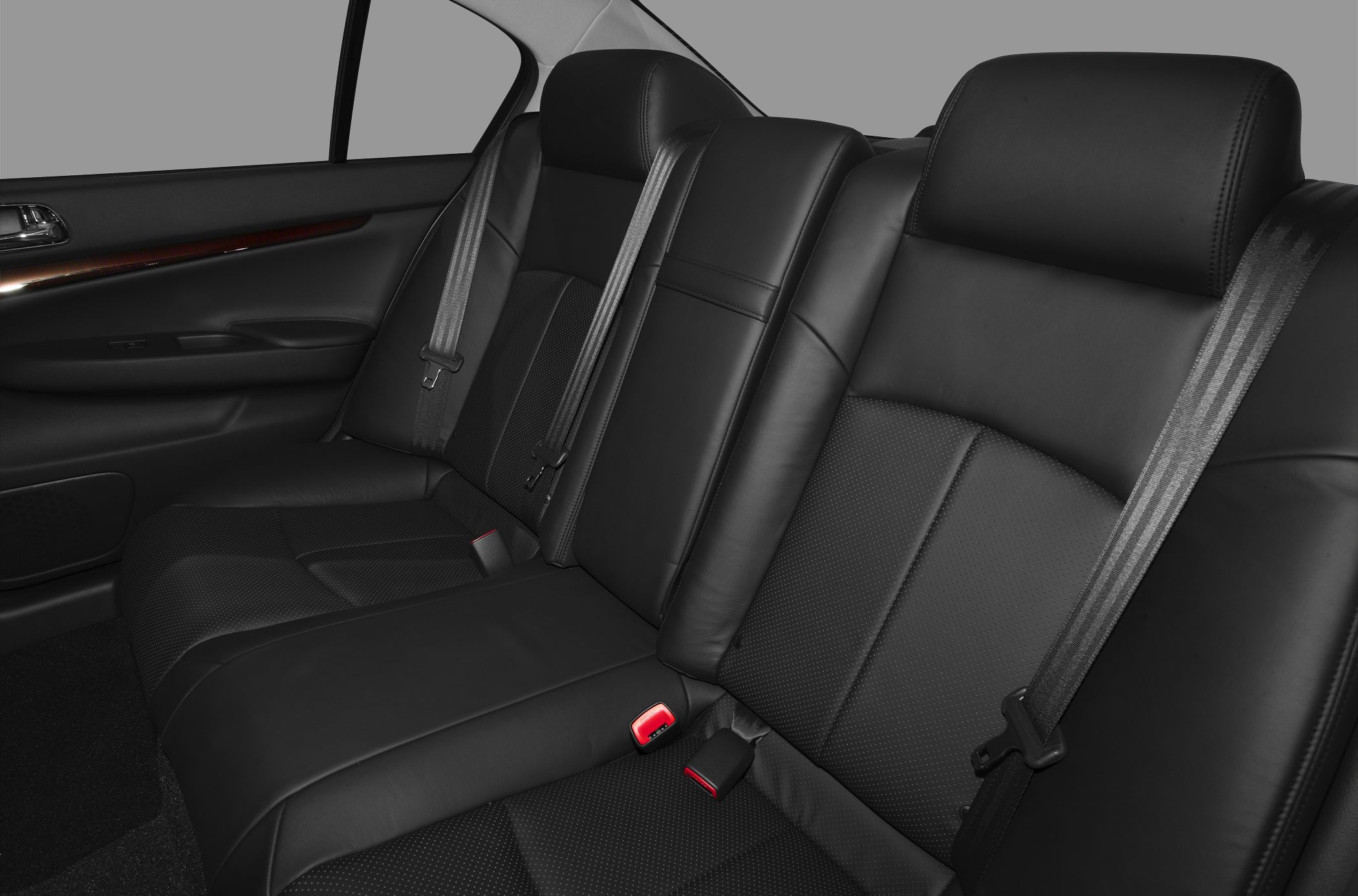 Black leather rear seating with seatbelts and wood trim door panel