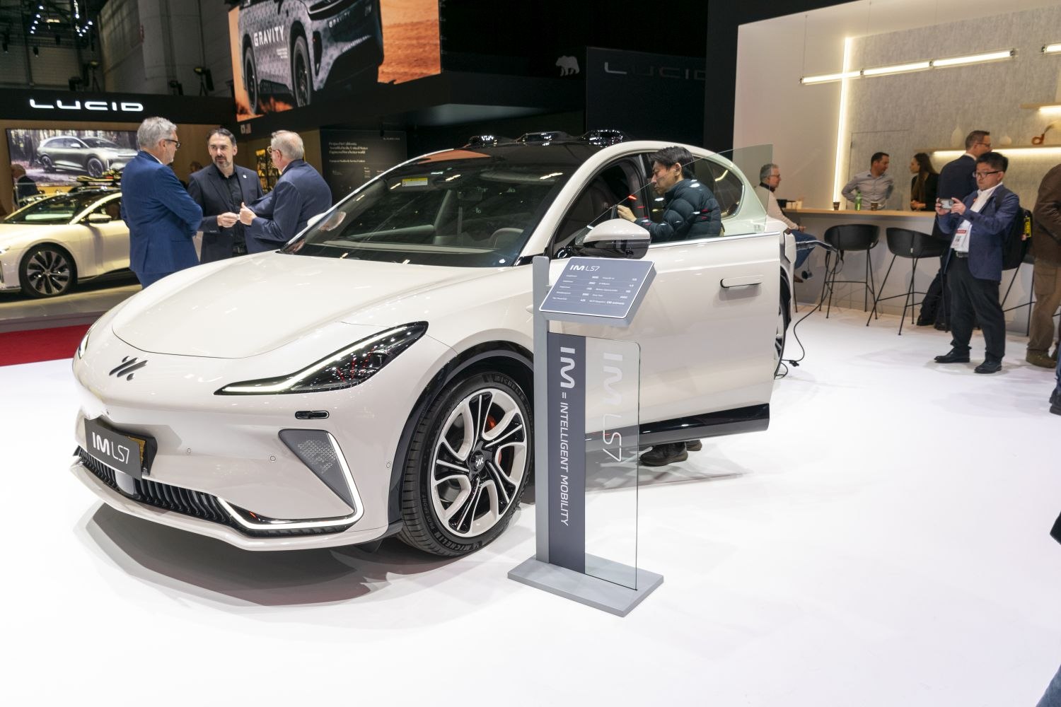 Front-side view of white electric sedan with open driver door