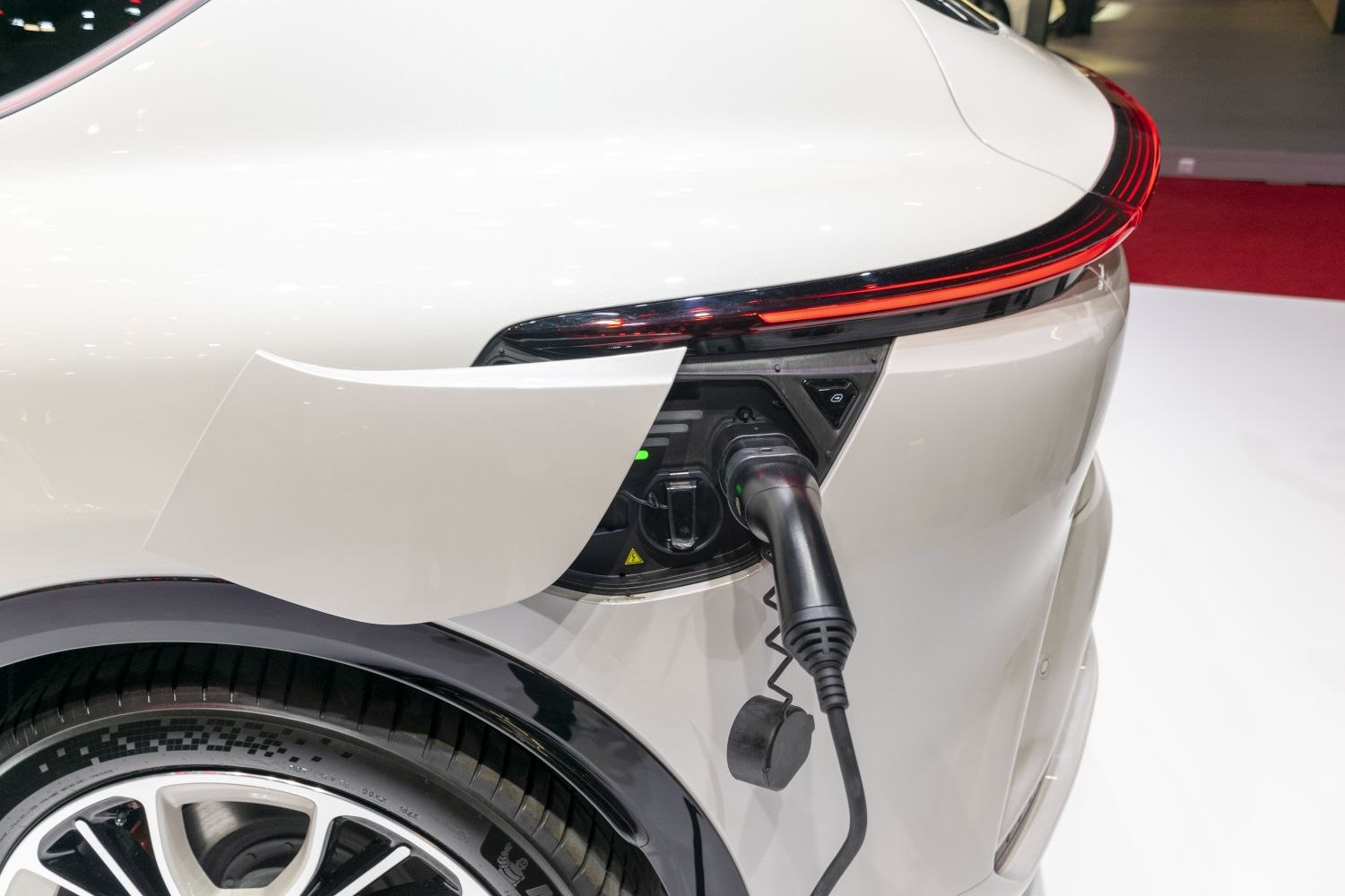 Electric vehicle charging port with rear taillight and wheel visible