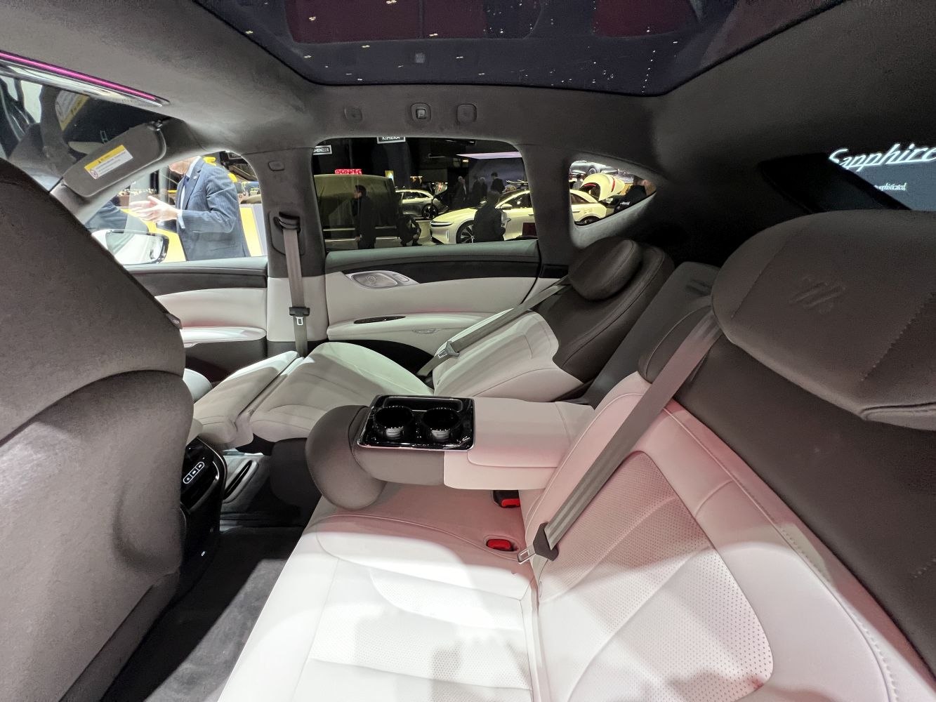 Luxurious rear interior with white leather and armrest cup holders
