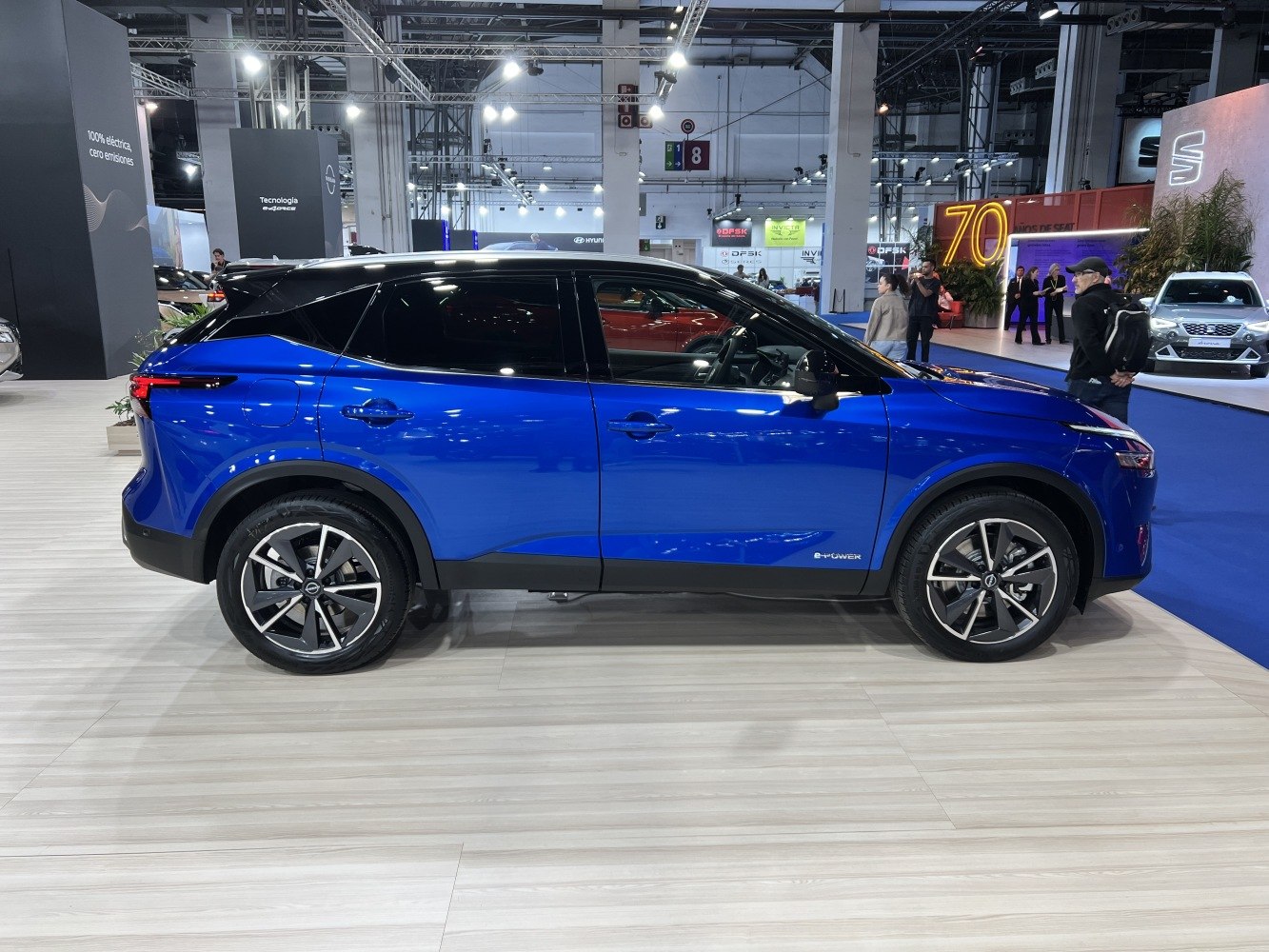 Side profile of a blue compact SUV with two-tone black roof and alloy wheels