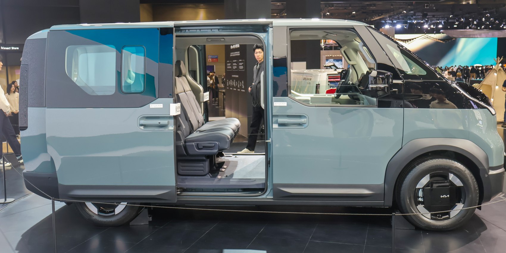 Sliding door open revealing spacious passenger seating and modern wheel design