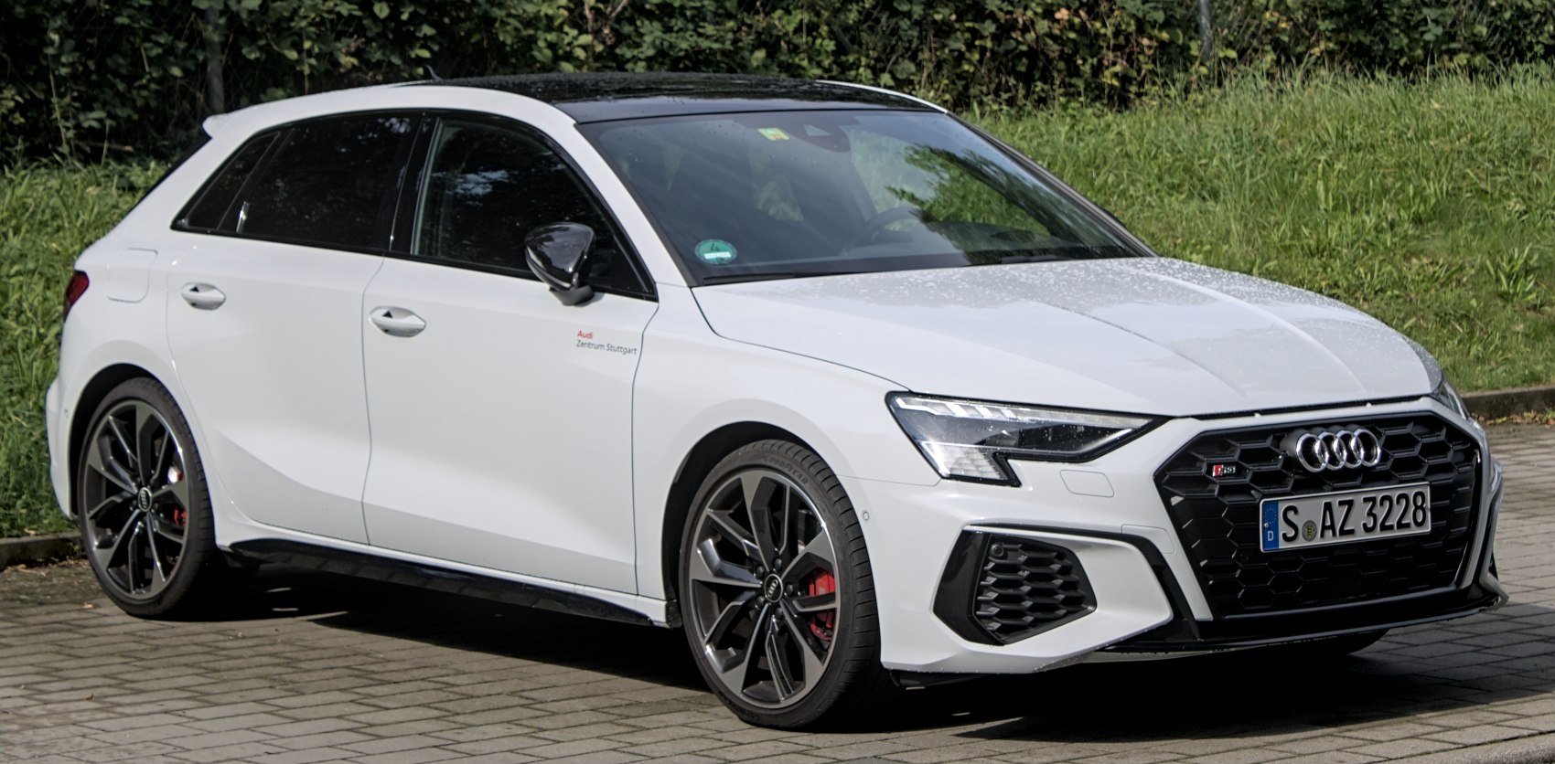 Front grille and alloy wheels of white sporty hatchback