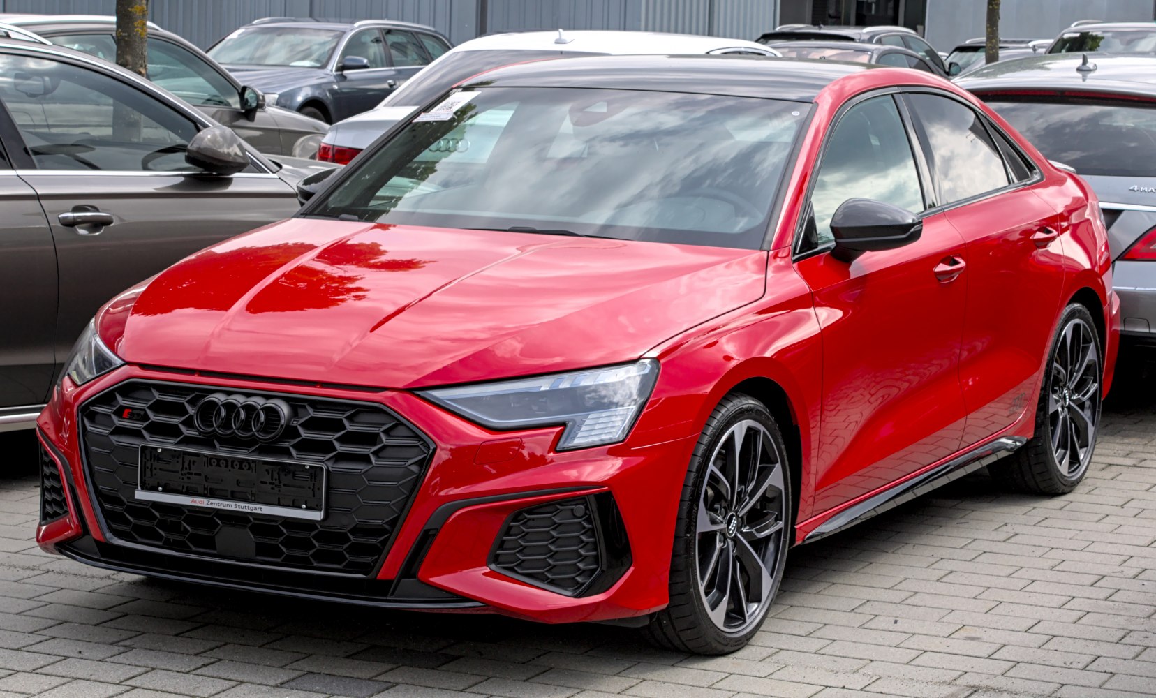 Sporty red sedan with honeycomb grille and sharp LED headlights
