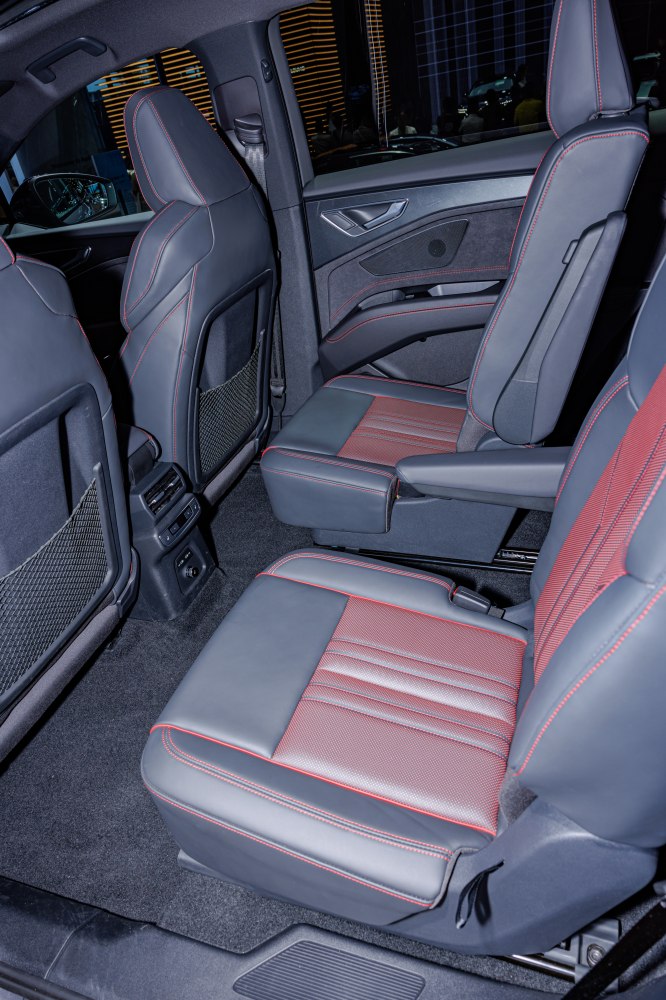 Rear passenger seats with leather and red stitching upholstery