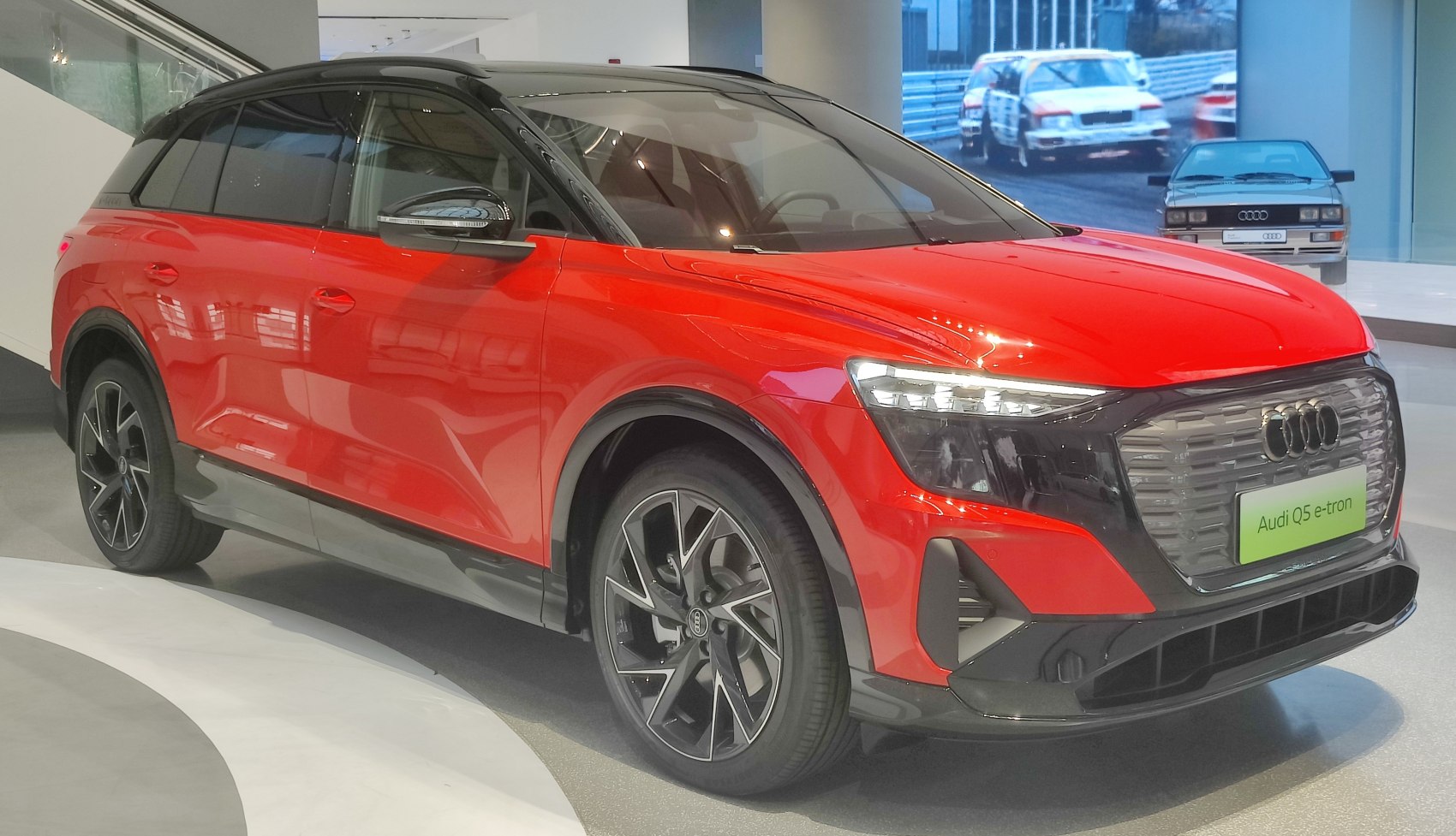 Front angle view of red electric SUV with LED headlights and futuristic grille