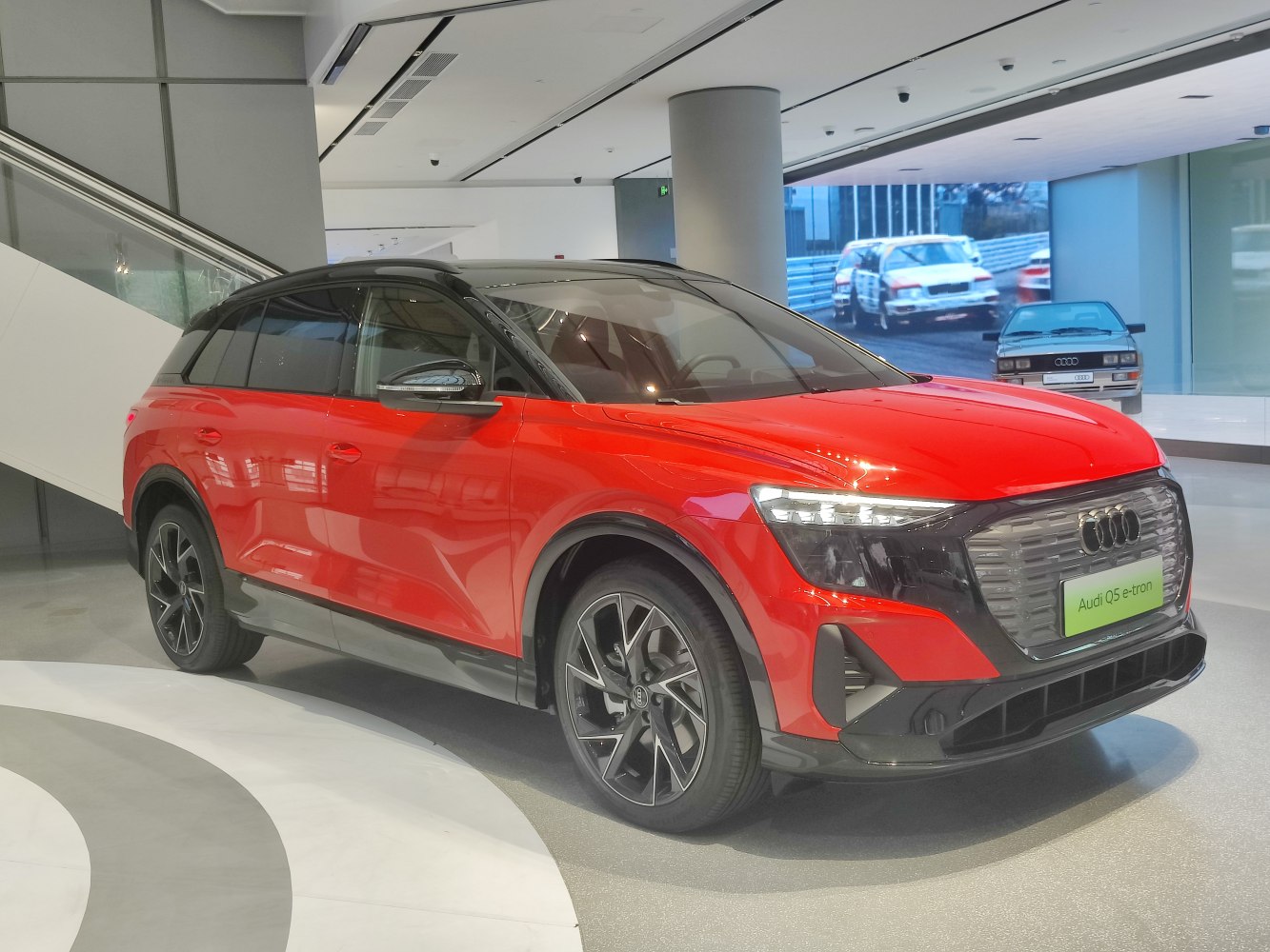 Front side view of red electric SUV with modern design and distinctive headlights