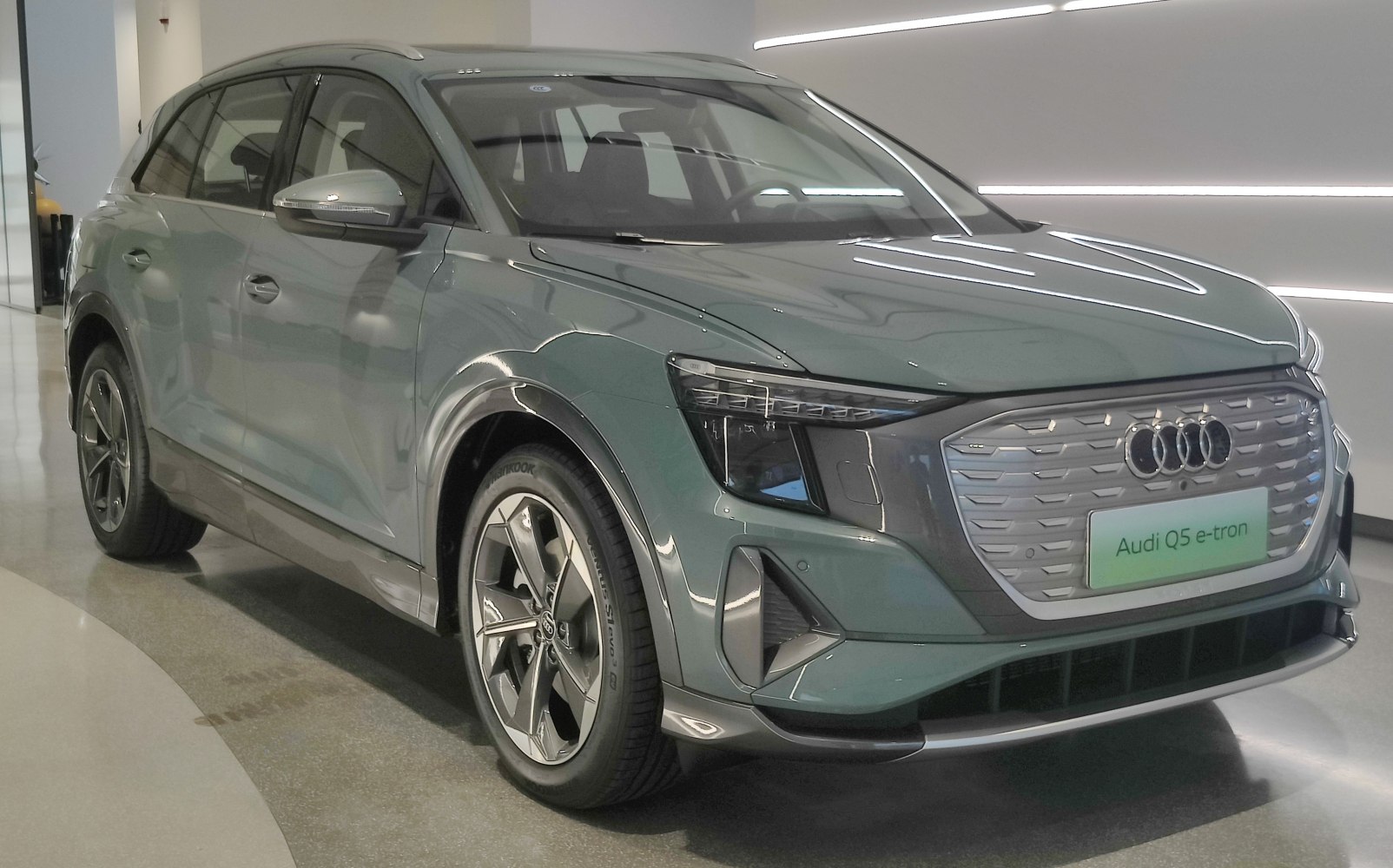 Front and side view of an electric SUV with closed grille and modern angular headlights.