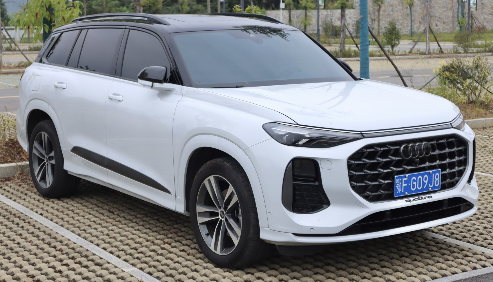 Large black hexagonal front grille and LED headlights on white SUV