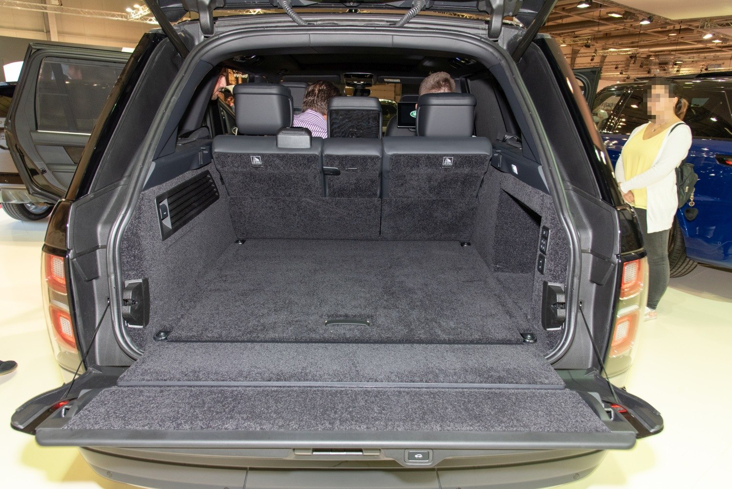 Large carpeted SUV cargo area with rear seats and fold-down tailgate.