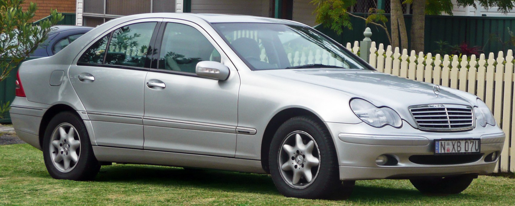 Silver sedan with dual round headlights and distinctive 5-spoke alloy wheels