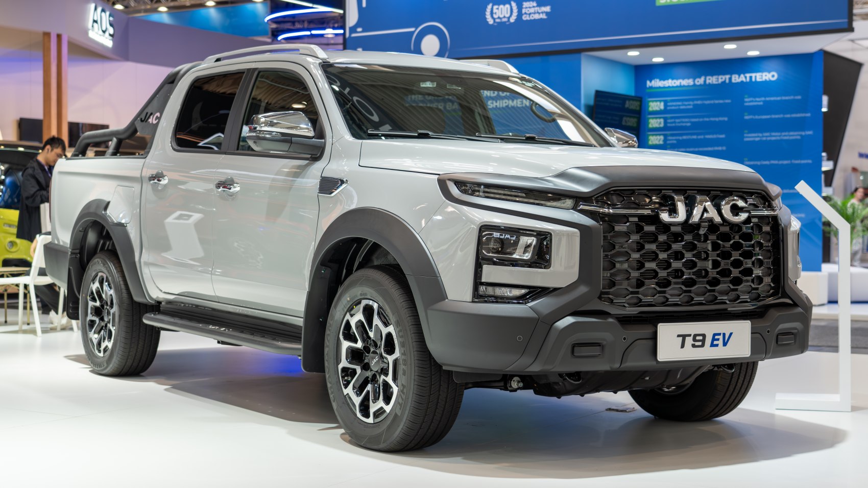 Front view close-up of electric double cab pickup with aggressive grille and modern LED headlights