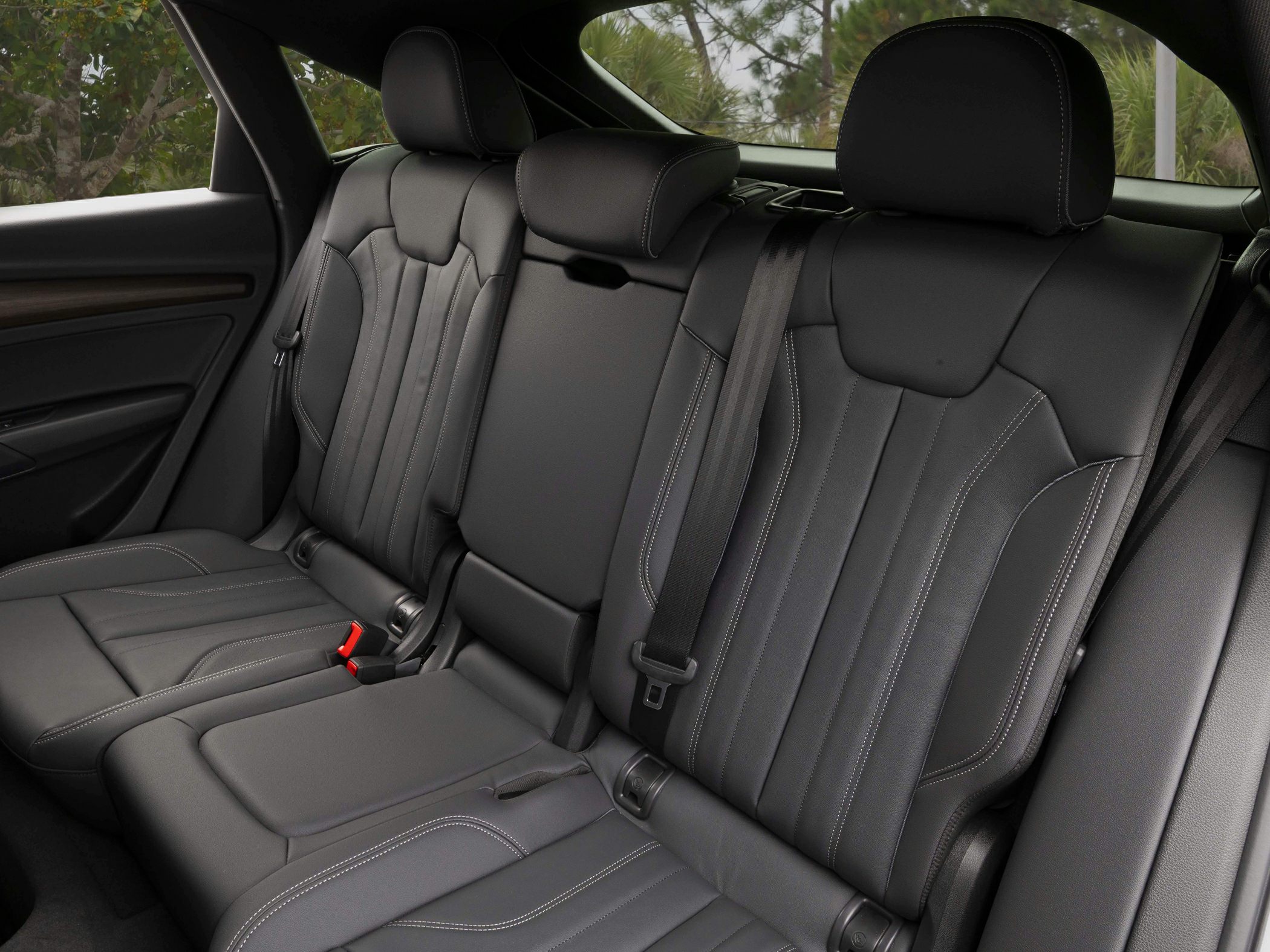 Black leather rear seats with contrast stitching and modern headrests.