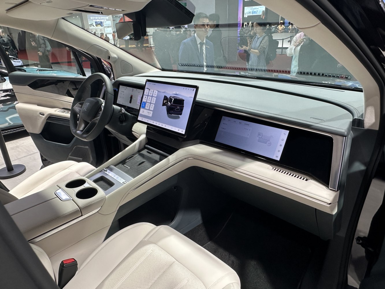 Dual touchscreen displays, modern dashboard, beige leather seats