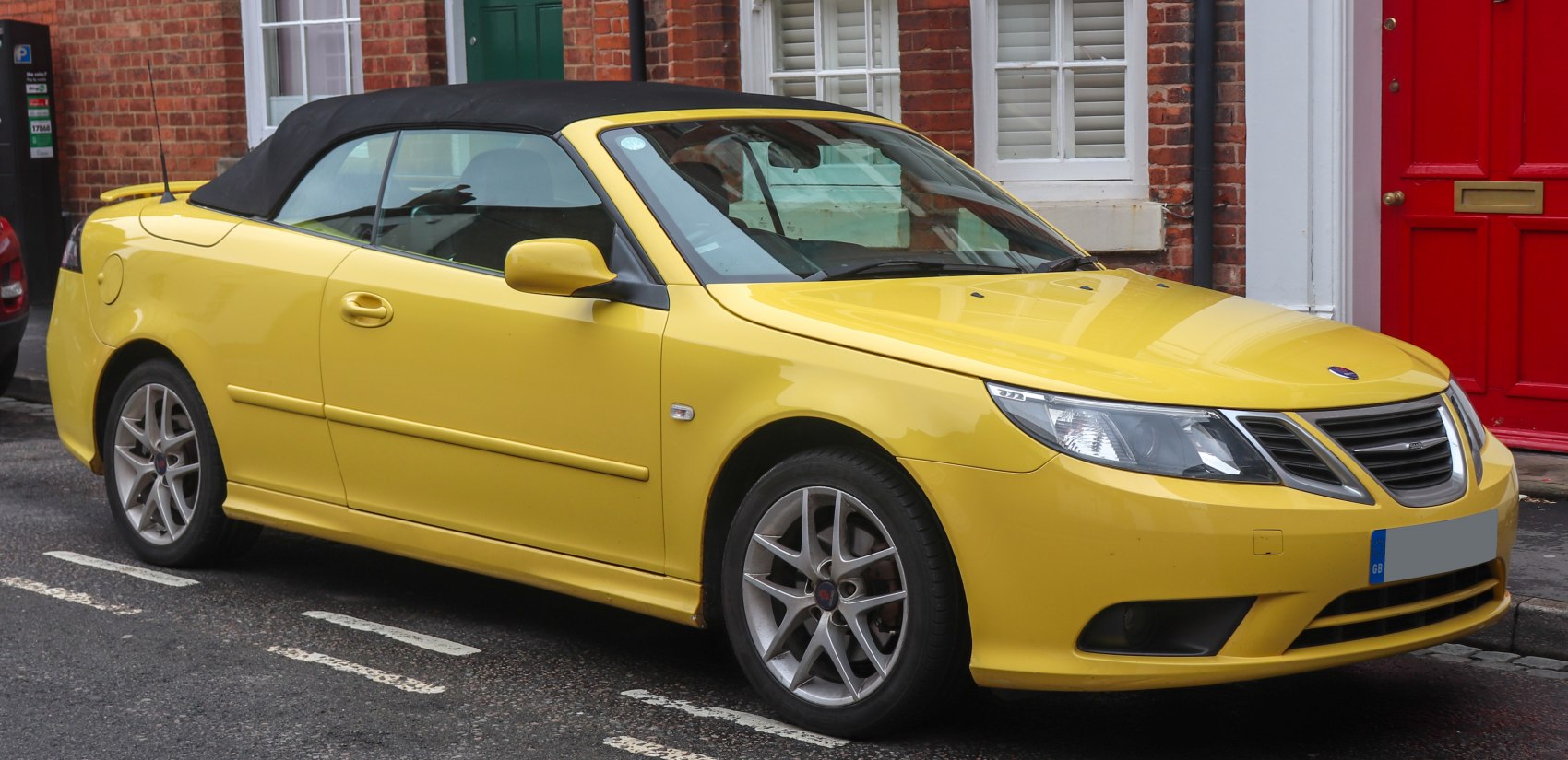 Yellow convertible with black soft top and alloy wheels