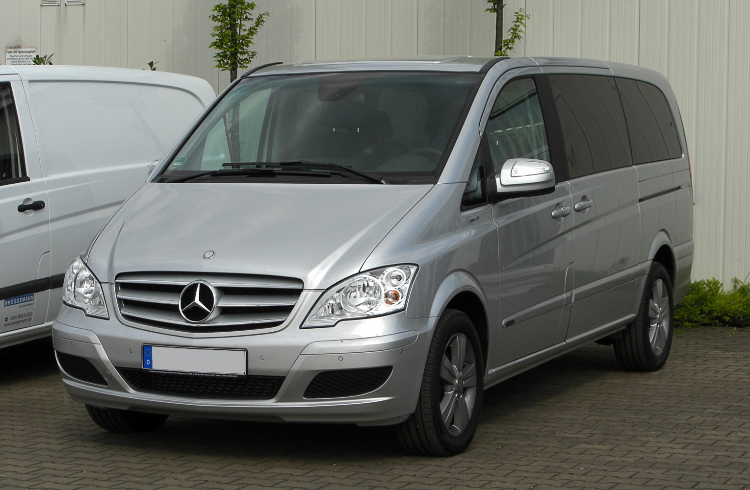 Silver multi-purpose van front view with headlights and grille