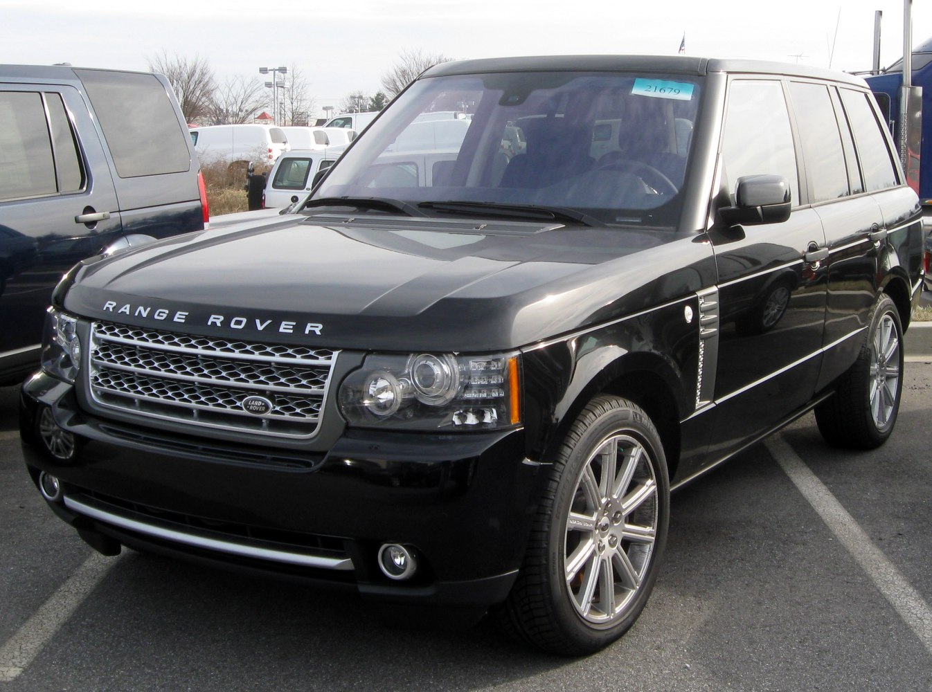 Black SUV with chrome grille and dual headlights from front-side view.