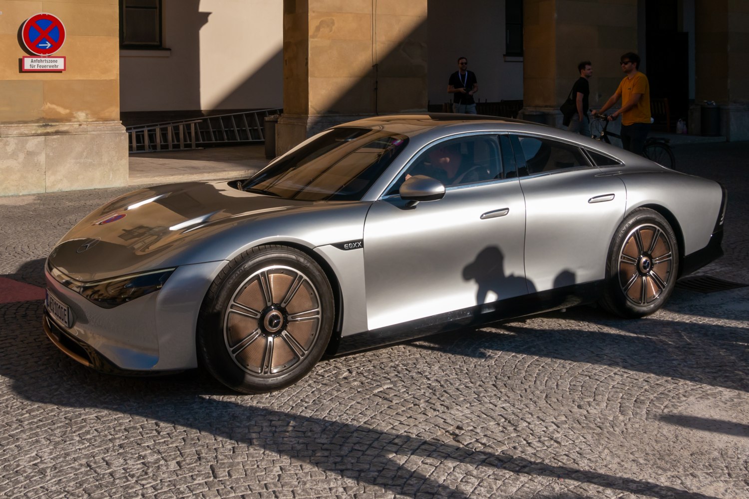 Aerodynamic silver electric car with futuristic wheels and sleek body design
