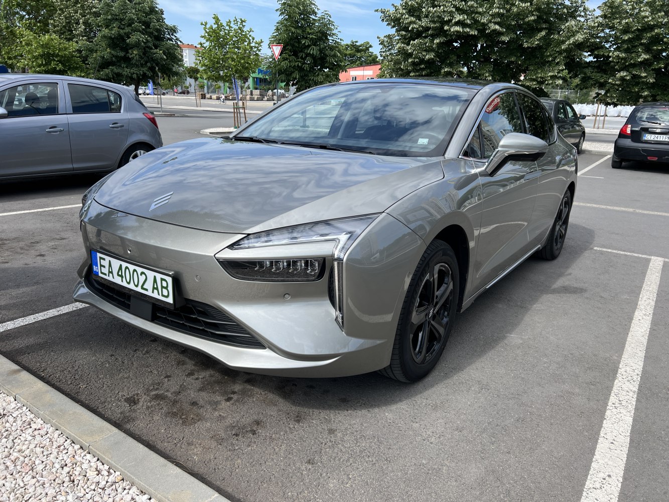 Front-angle electric sedan with sharp LED headlights and aerodynamic smooth body.