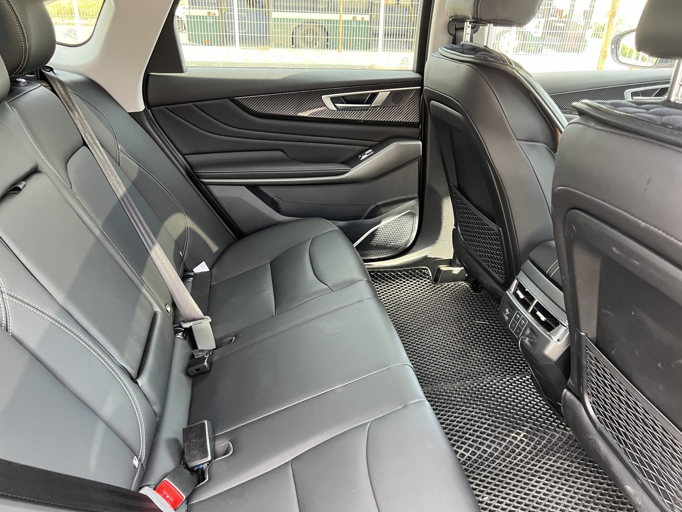 Rear seat interior with black leather upholstery and modern design.