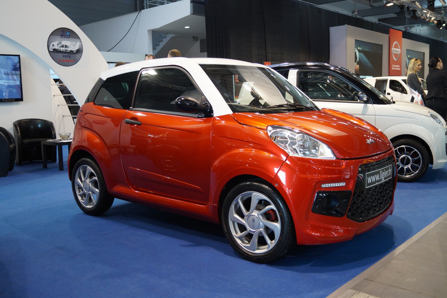Red compact hatchback with white roof and sporty alloy wheels