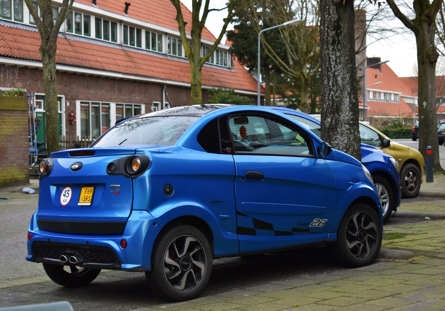 Compact microcar rear side with sporty blue design and dual exhausts