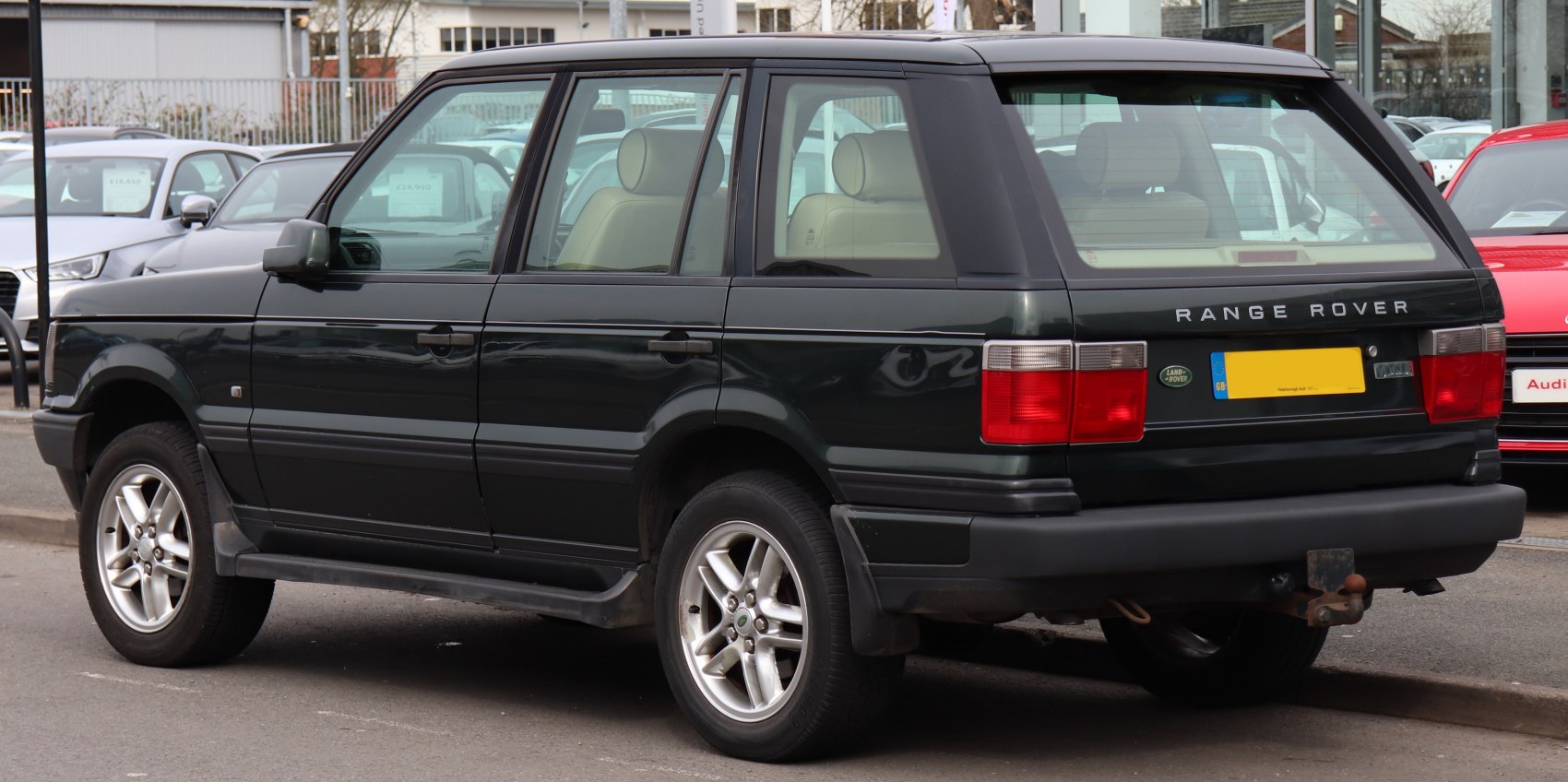 Rear and side view of vintage SUV with angular design and alloy wheels.