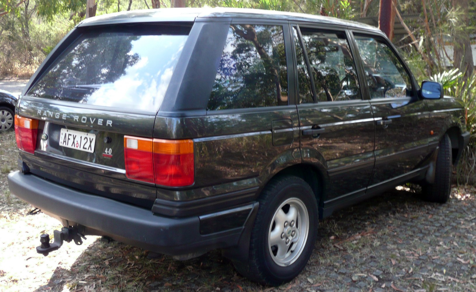 Rear side view with tail lights, rear window, and alloy wheels