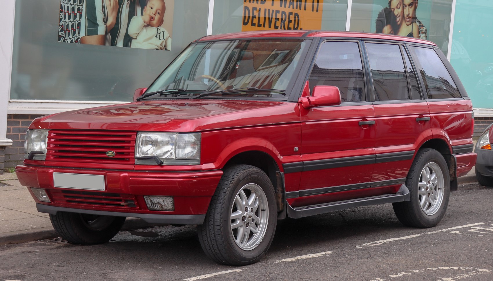 Red SUV with boxy design and distinctive front grille from the mid-1990s