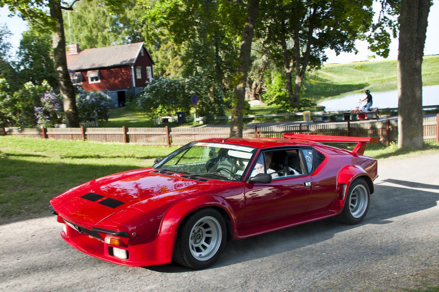 Red classic sports car with wide body and large rear wing