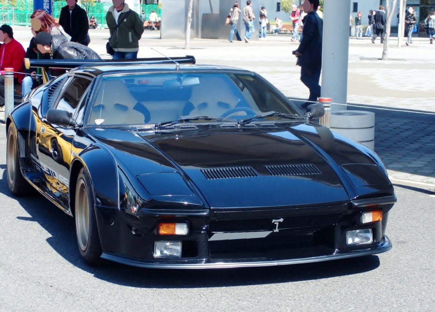 Black sports coupe with widebody fenders and aerodynamic hood vents